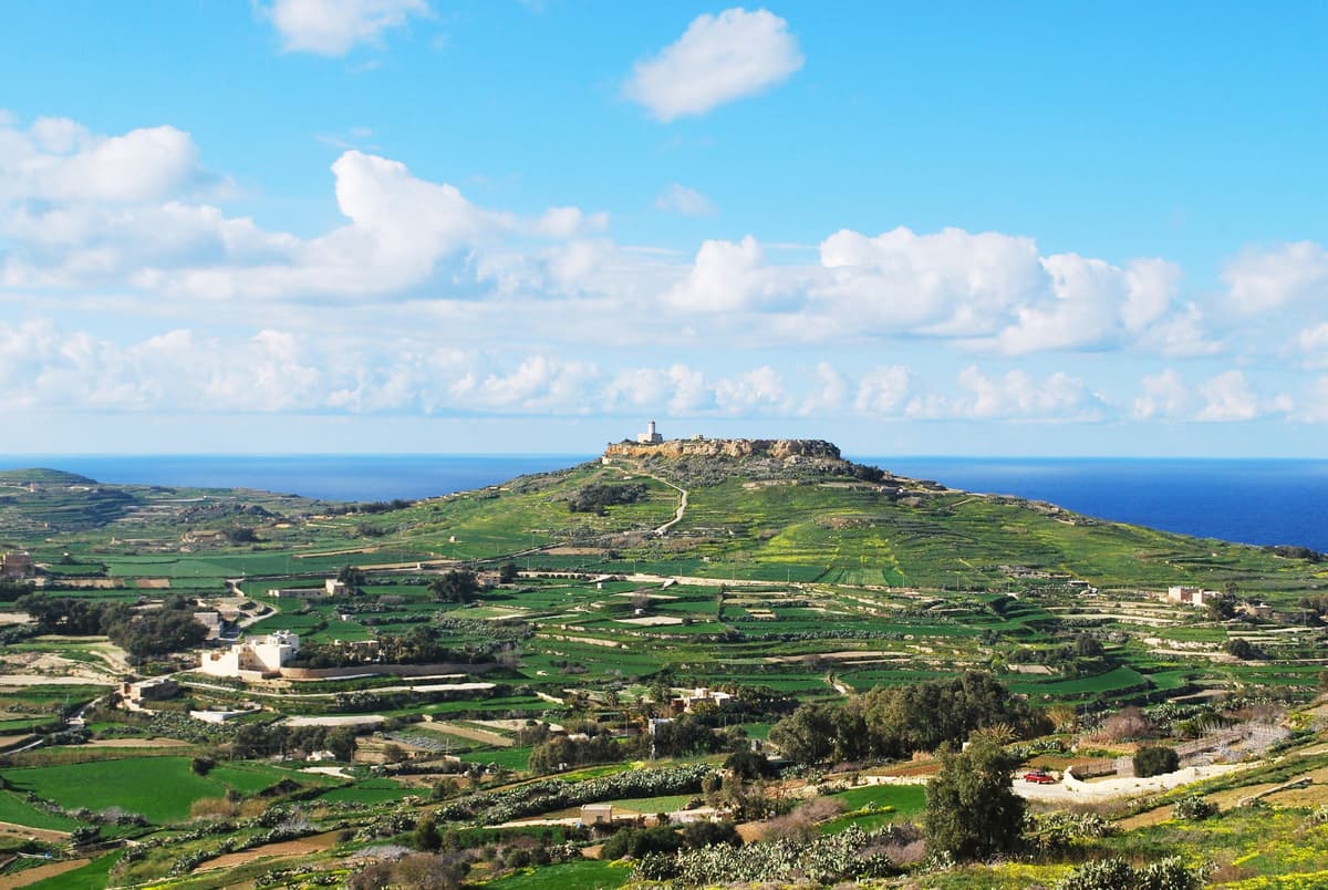 Green Gozo countryside with the Victoria Citadel on the hilltop - Gozo day tours from Malta